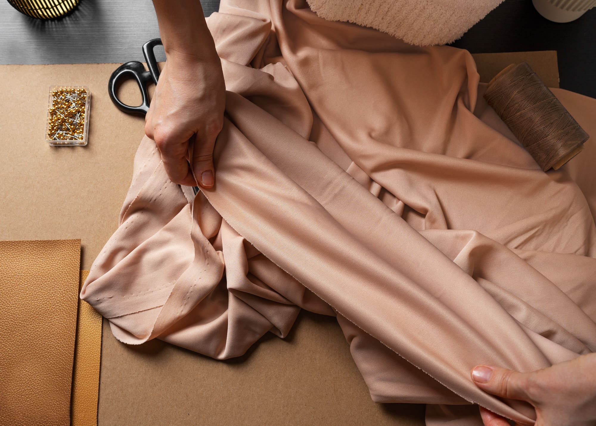 Hand adjusting fabric for alterations with sewing tools, highlighting expert garment care at My Best Cleaners in Clinton, Maryland.